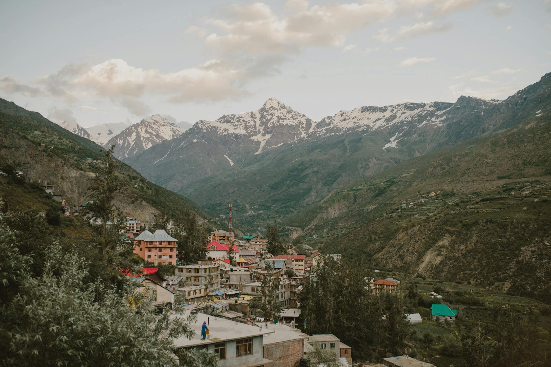 old town surrounded by mountains against cloudy sundown sky