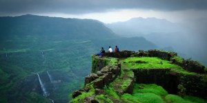 A breathtaking view of Rajmachi Fort in Lonavala during the monsoon, surrounded by lush greenery, misty hills, and cascading waterfalls.