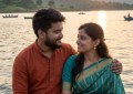 Young Indian couple sitting by Panshet reservoir backwaters at golden hour, hills in background, warm natural light, int