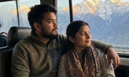 Young Indian couple in shared taxi looking out at snow-capped Kashmir peaks, golden hour light, candid travel moment, wa