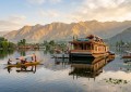 Wide-angle morning shot of a houseboat on Dal Lake with Zabarwan mountain range in soft golden light, shikara boats visi
