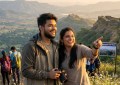 Young Indian couple enjoying scenic mountain viewpoint near Pune, golden hour lighting, candid moment, travel photograph