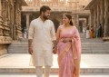 Couple walking hand-in-hand on clean stone temple steps at dawn, warm golden light, peaceful atmosphere, traditional Ind