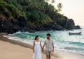 Secluded Goa beach cove framed by cliffs, soft morning light, turquoise water, single couple walking on empty sand, natu
